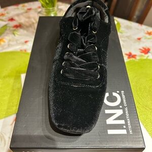 Black velvet  sneaker  featuring elegant details at the laces.